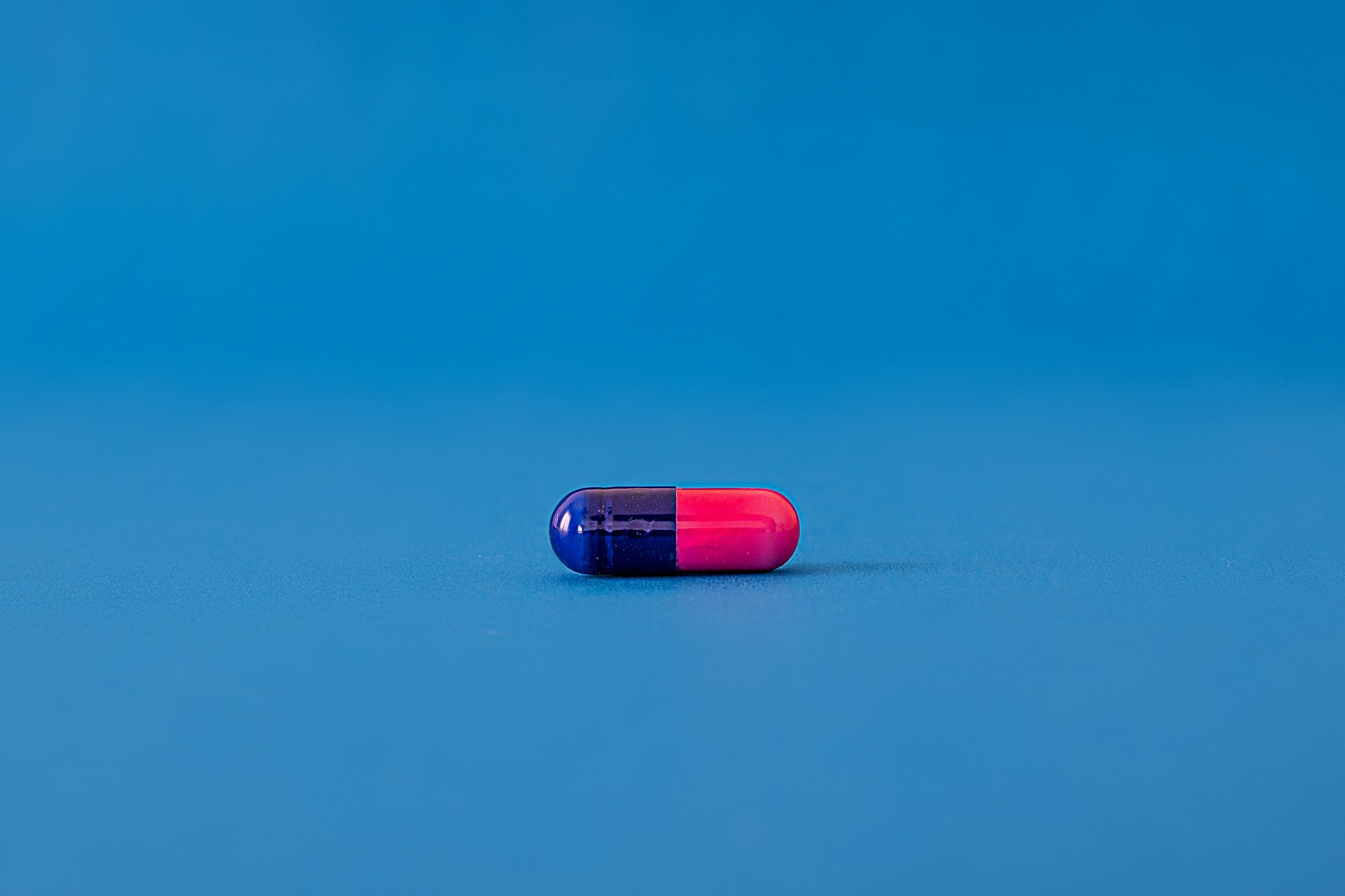 blue and pink pill on a blue background